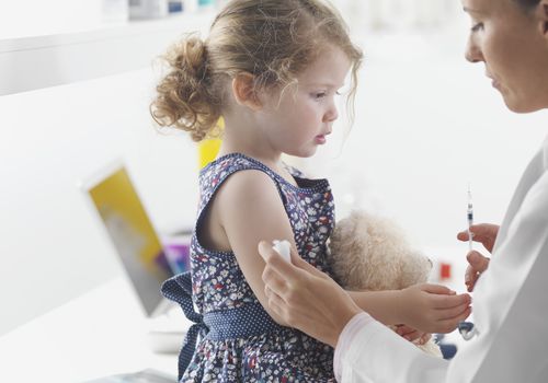 Doctor giving toddler girl a shot