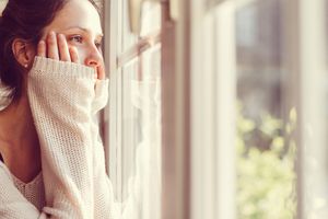 穿白毛衣的女人看着窗外。