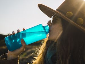 徒步旅行中的女子用水瓶喝水