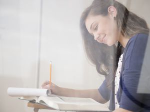 teenage girl writing at desk