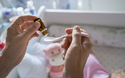 父母用勺子给婴儿喂益生菌