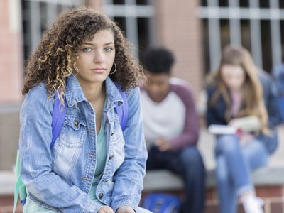 Sad-looking college student with classmates in background