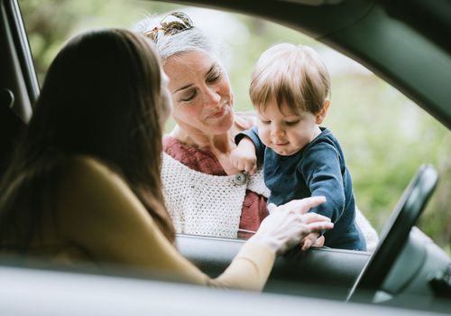 A picture of a mother leaving her child with his grandmother