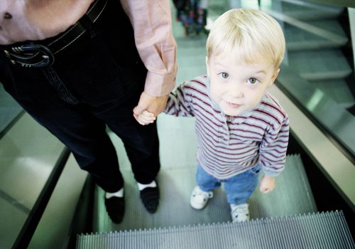 Young boy with mother on escalator
