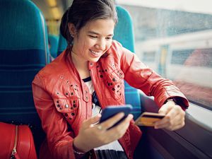 Young teenage girl is shopping online/making reservation in the train